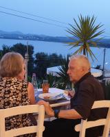 un hombre mayor y una mujer sentadas en una mesa en Stefanosplace ApartHotel Sea View, en Barbati