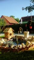 un pequeño estanque con una casa de aves en un patio en Apartman Peric, en Ðakovo