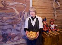 a woman is holding a basket of oranges at Hotel Hetan Majatalo in Enontekiö