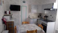 a kitchen with white cabinets and a table with chairs at FLAB &#39; DES VENTS in Le Tréport