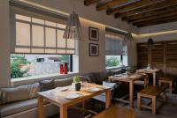 un comedor con mesas, sofás y ventanas en Basilico Suites Adults Only by Estia, en Gouves