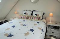 a bedroom with a large white bed with pillows at LILWENN in Guidel