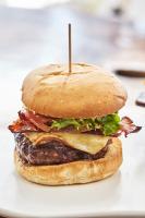 Una hamburguesa con carne y lechuga en un plato blanco. en Hacienda Na Xamena, Ibiza, en Na Xamena