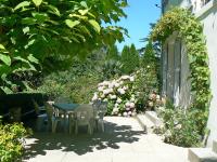 a patio with a table and chairs and flowers at Holiday Home Le chant des milans by Interhome in Ondres