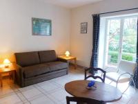 a living room with a couch and a table at Holiday Home Le chant des milans by Interhome in Ondres