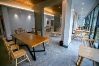 uma sala de jantar com mesas, cadeiras e janelas em National Forest Park(Yangjiajie ) MINI Inn em Zhangjiajie