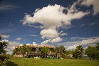 a house on a green field with a cloudy sky at Gîte Les Bourdettes in Auvillar