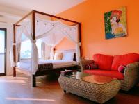 a bedroom with a canopy bed and a couch at Ibali Hostel in Magong