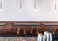 a bar with a brown leather couch and chairs at Langley Hôtel Tignes 2100 in Tignes