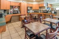 ein Restaurant mit Tischen und Stühlen und einer Küche in der Unterkunft Microtel Inn &amp; Suites by Wyndham Uncasville Casino Area in Uncasville