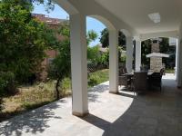 eine Außenterrasse mit einem Tisch und Stühlen darauf in der Unterkunft Villa Iva in Medulin