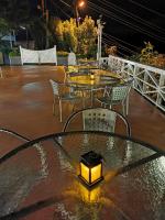 a table and chairs on a patio at night at Alishan Tea Garden B&amp;B in Fenqihu