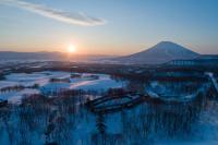 una puesta de sol de invierno con una montaña en el fondo en Zaborin, en Kutchan