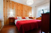 a bedroom with a red bed with wooden walls at Complejo Rural Huerta Grande in Algeciras