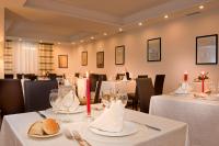 un comedor con mesas con manteles blancos y velas en Cardinal Hotel St. Peter, en Roma