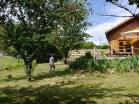 a man standing in a yard next to a house at Le Chalet in Prémian