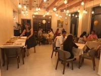 un grupo de personas sentadas en mesas en un restaurante en Hotel Miki, en Durrës