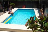 two girls are sitting in a swimming pool at Hostel Mamallena in Panama City