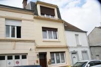 a building with two windows and a car parked in front at Gite Louvre Opale in Desvres