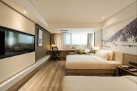 Una habitación de hotel con dos camas y un televisor de pantalla plana. en Atour Harbin Museum Hotel, en Harbin