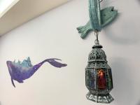 a lantern hanging from a wall with a mermaid on it at Hualien Dawan B&amp;B in Ji&#39;an