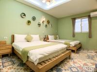 two beds in a room with green walls at Hualien Dawan B&amp;B in Ji&#39;an