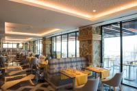 een restaurant met tafels en stoelen en grote ramen bij TUI BLUE Seno - Adults Only in Sarigerme