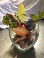 een glazen schaal gevuld met groenten en fruit op een tafel bij Hôtel des Voyageurs Restaurant Traiteur in Bagnols