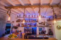 Un bar con botellas en la pared y luces. en Agia Anna Beachfront Boutique, en Paraga