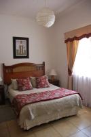 Un dormitorio con una cama grande con una manta roja. en Hotel Empresarial, en Los Ángeles