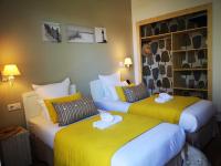- 2 lits dans une chambre d&#39;hôtel de couleur jaune dans l&#39;établissement Hôtel Le Vert Bois, à Dolus-d&#39;Oléron