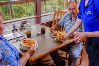 eine Gruppe von Menschen sitzt um einen Tisch herum und isst in der Unterkunft Carter Caves State Resort Park in Olive Hill