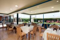 een restaurant met witte tafels en stoelen en grote ramen bij 4S Hotel Dahab in Dahab