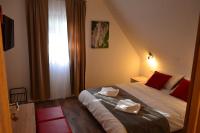 - une chambre avec un lit doté d&#39;oreillers rouges et une fenêtre dans l&#39;établissement Natura Plitvice Lakes, aux lacs de Plitvice