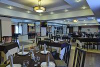 卡拉甘达祖穆拉特酒店的餐厅里有桌椅