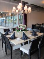una sala da pranzo con tavolo, sedie e fiori di Hotel Käenpesä a Ylivieska