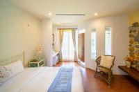 a bedroom with a bed and a chair and windows at Mong Shan Homestay in Kenting