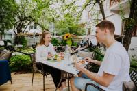 Een man en een vrouw die aan een tafel eten. bij Harmooni Suites in Jyväskylä