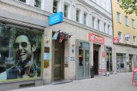 Una tienda con una foto de un hombre en un escaparate. en Pension Locarno, en Múnich