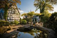 un jardín con un estanque frente a un edificio en Malerwinkel Hotel, en Bergisch Gladbach