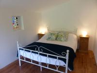 a bedroom with a white bed with two night stands at Hameau de Montcabirol - Foix in Mirepoix