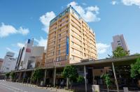 青森市にあるホテルマイステイズ青森駅前の市道の高い黄色の建物