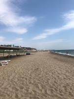 a beach with chairs and people on the sand at Apartment near the sea in Gribovka
