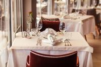 シェーナにあるHotel Schlosswirtの白いテーブルクロスがかけられたテーブルとワイングラス