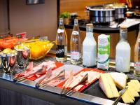 una mesa con un plato de comida y botellas de leche en Novotel Lille Aéroport, en Lesquin