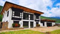 Casa blanca grande con techo marrón en The Village Lodge Bumthang, en Bumtang Tang