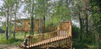 a tree house with a deck in the woods at LA CABANE PERCHEE in Villelaure