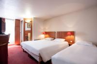 Una habitación de hotel con dos camas y un televisor. en Hôtel inn design Sancé, en Mâcon