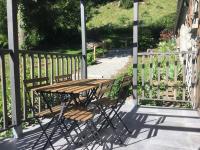 a wooden table and chairs on a porch at Au chalet des quatre saisons in Ax-les-Thermes