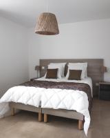a bedroom with a large bed with white sheets at Au chalet des quatre saisons in Ax-les-Thermes